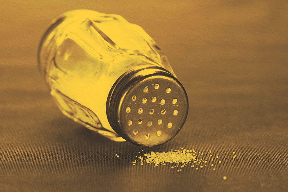 Salt shaker with salt on a table