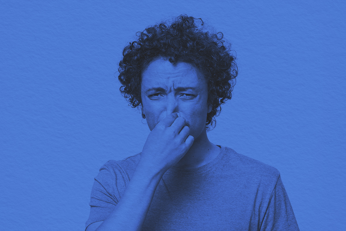 young man holding his nose