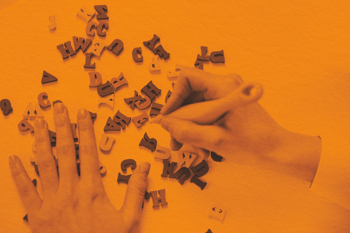 Letters of the English alphabet in hands with pen