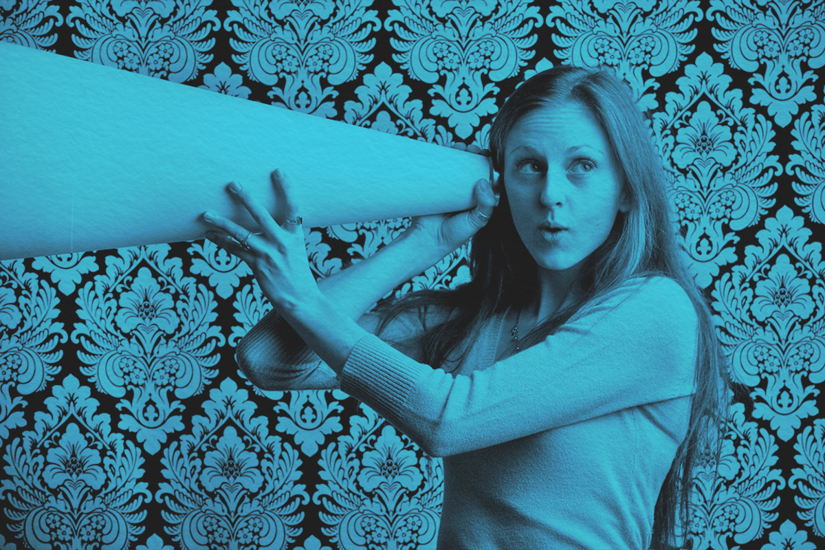 Young woman listening intently to what she hears through a megaphone