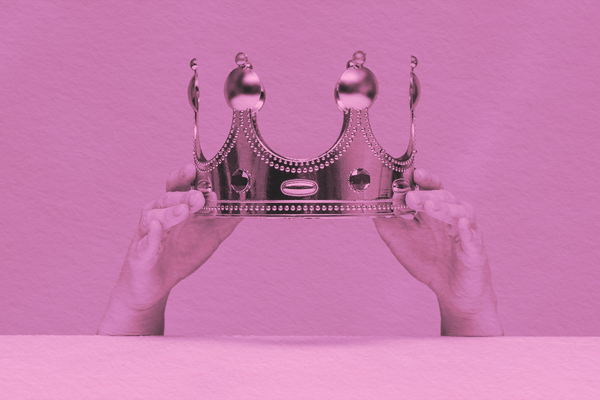 Crown in hands close up above a table