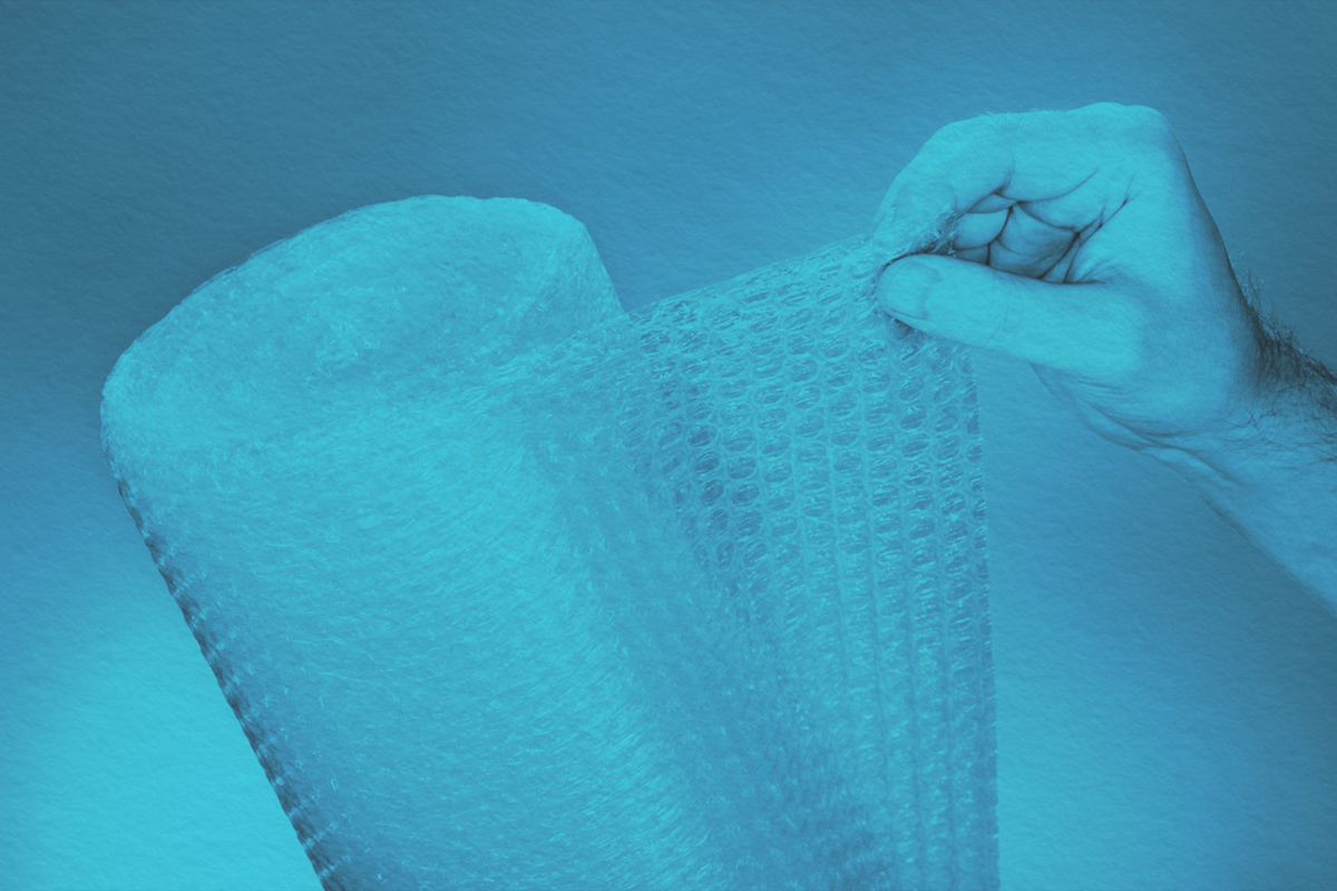 Man holding a roll of plastic bubble wrap
