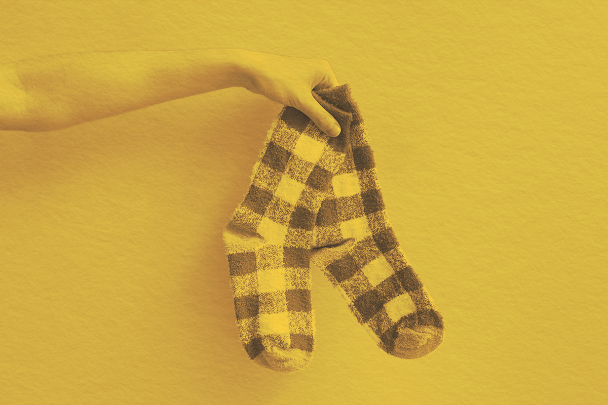 Holding out a pair of socks on solid background
