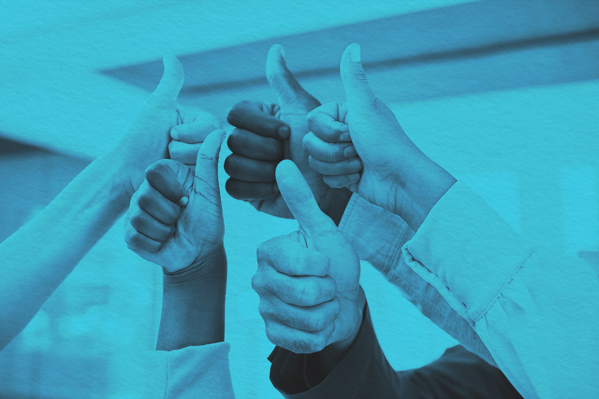 Close-up of a team giving thumbs up symbol
