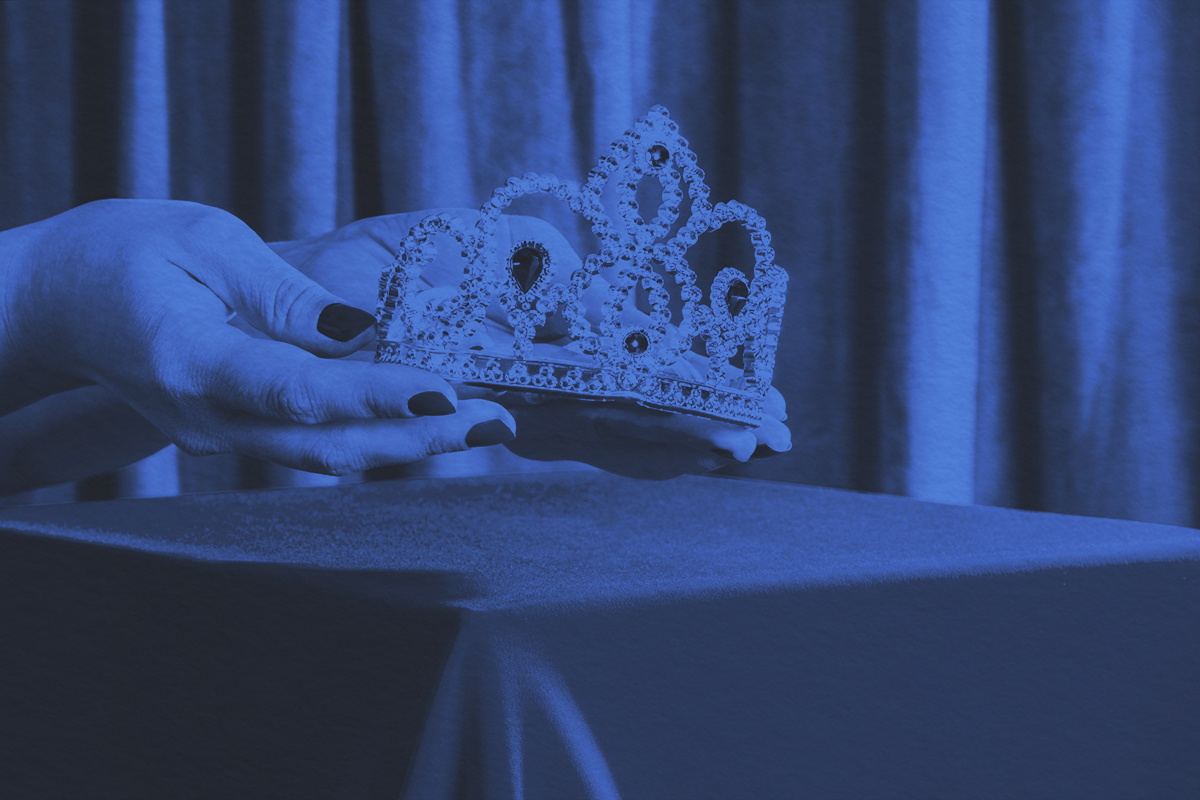 Hands hold crown with precious stones