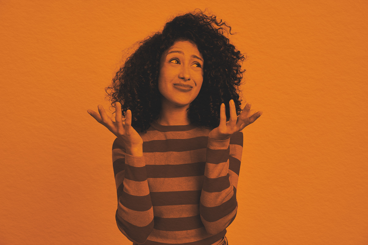 Puzzled young woman shrugging shoulders