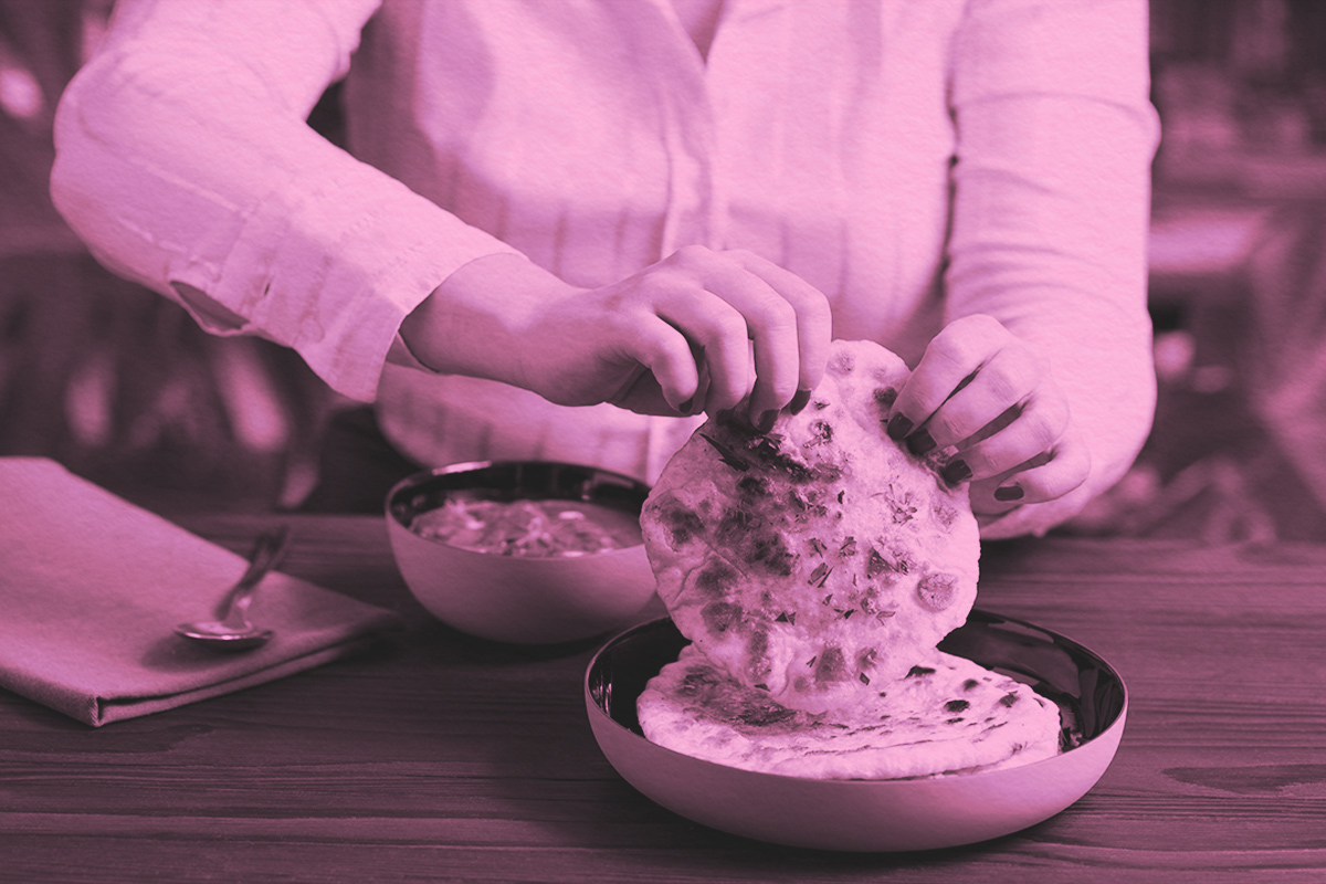 woman eating curry and naan bread