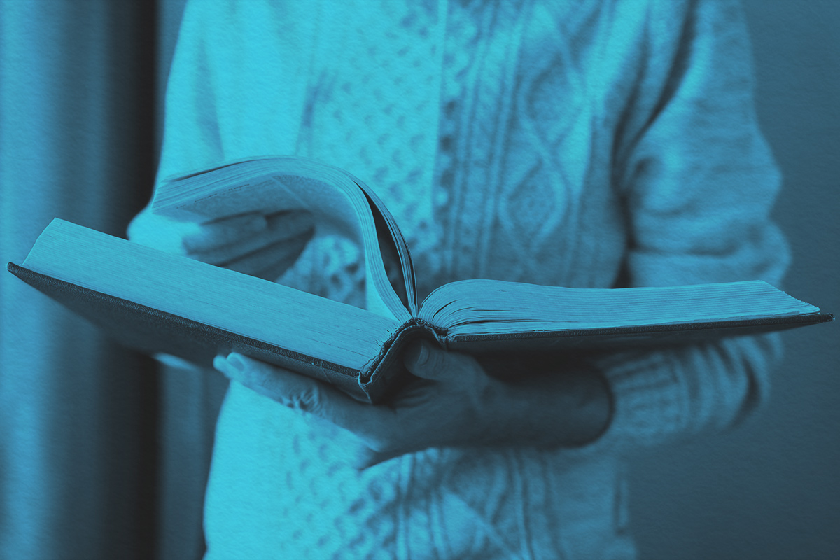 man is leafing through a huge old dictionary