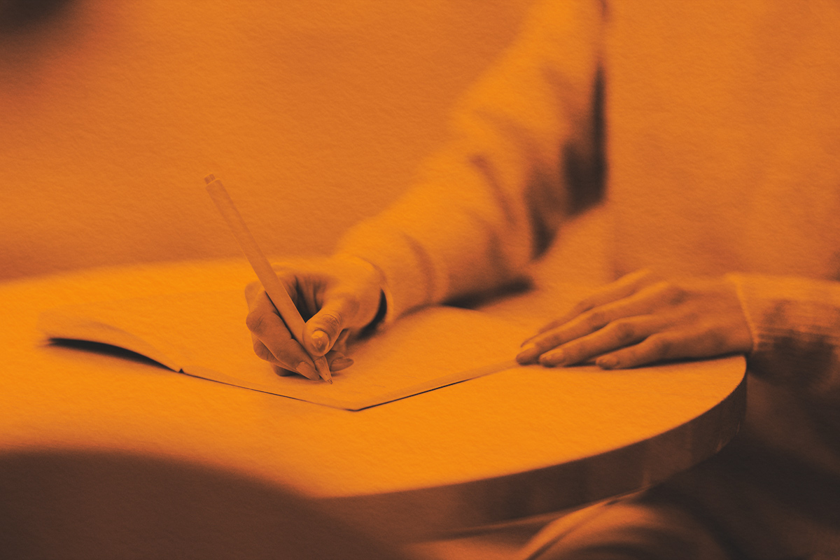 Close-up of a person writing in a notebook