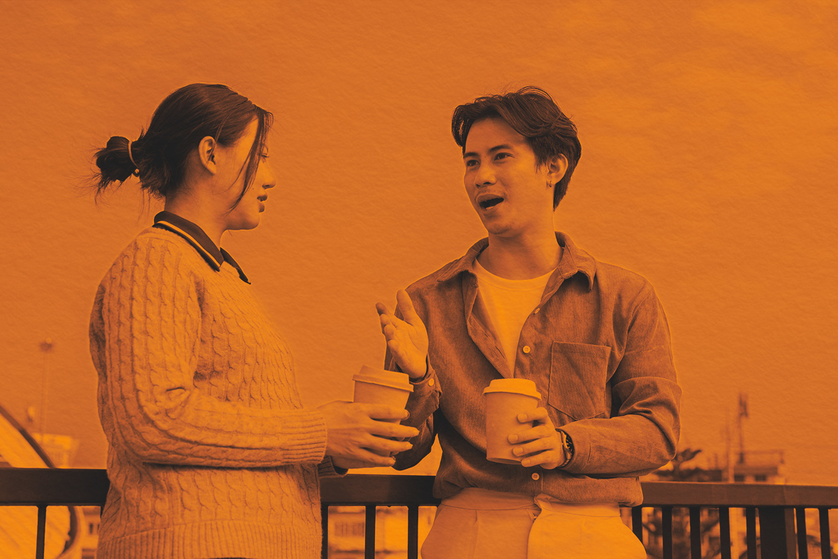 Two people engage in a conversation on a rooftop