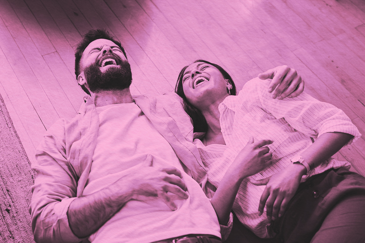 Couple laughing together on the living room floor
