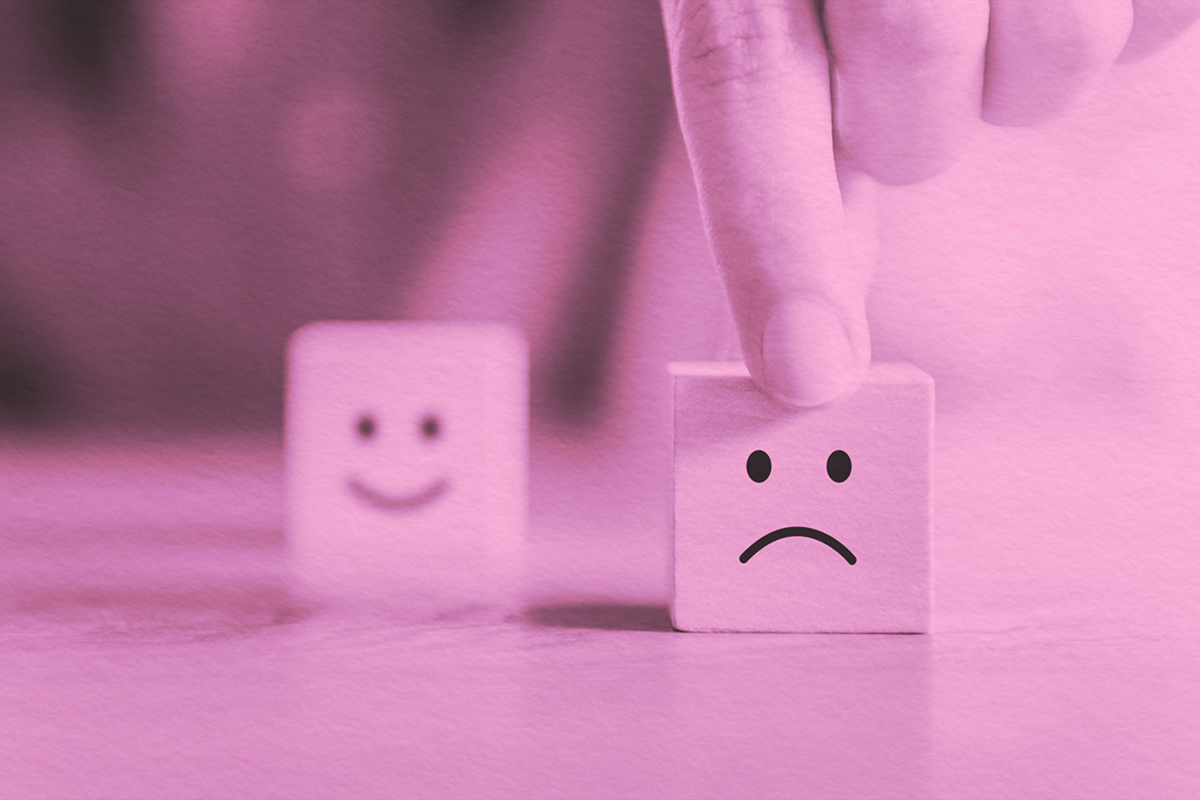 Happy face block in background, sad face block in foreground