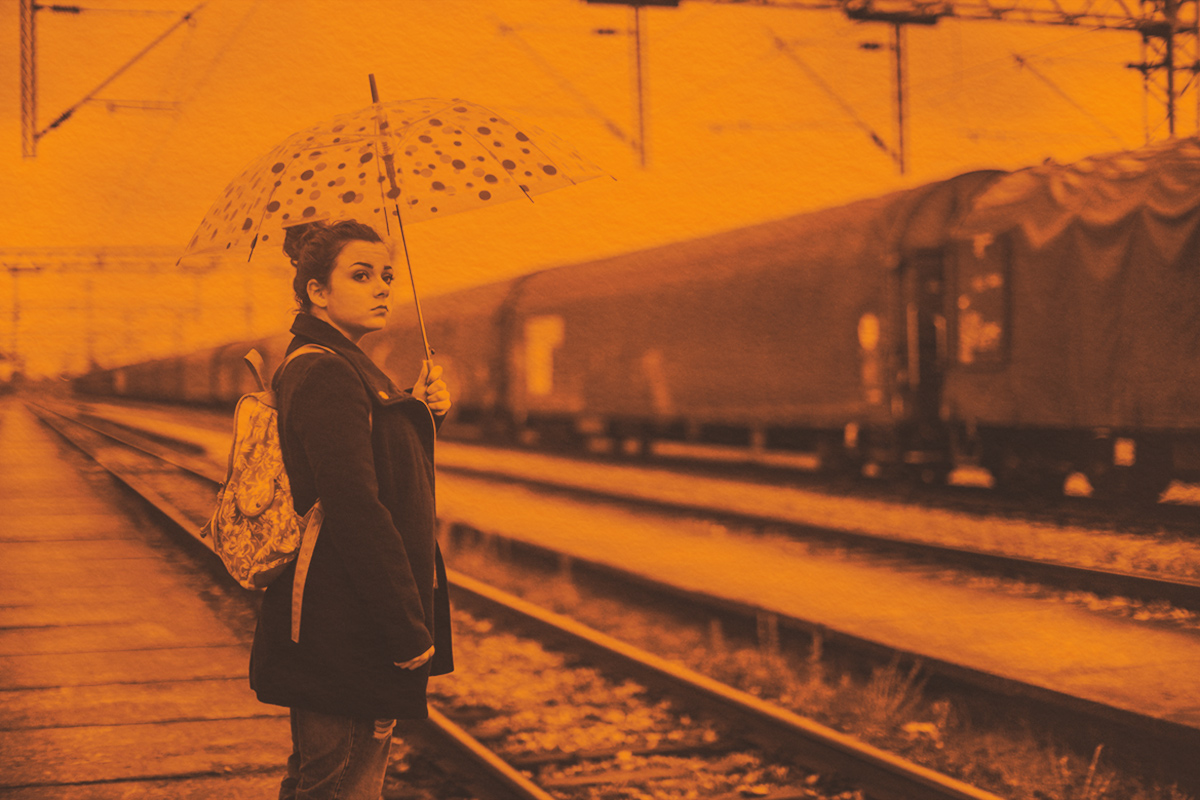 Woman waiting for train in the rain