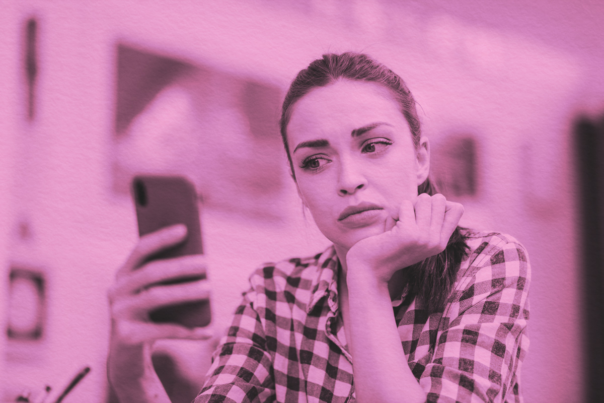 Woman reading text of phone with confused facial expression
