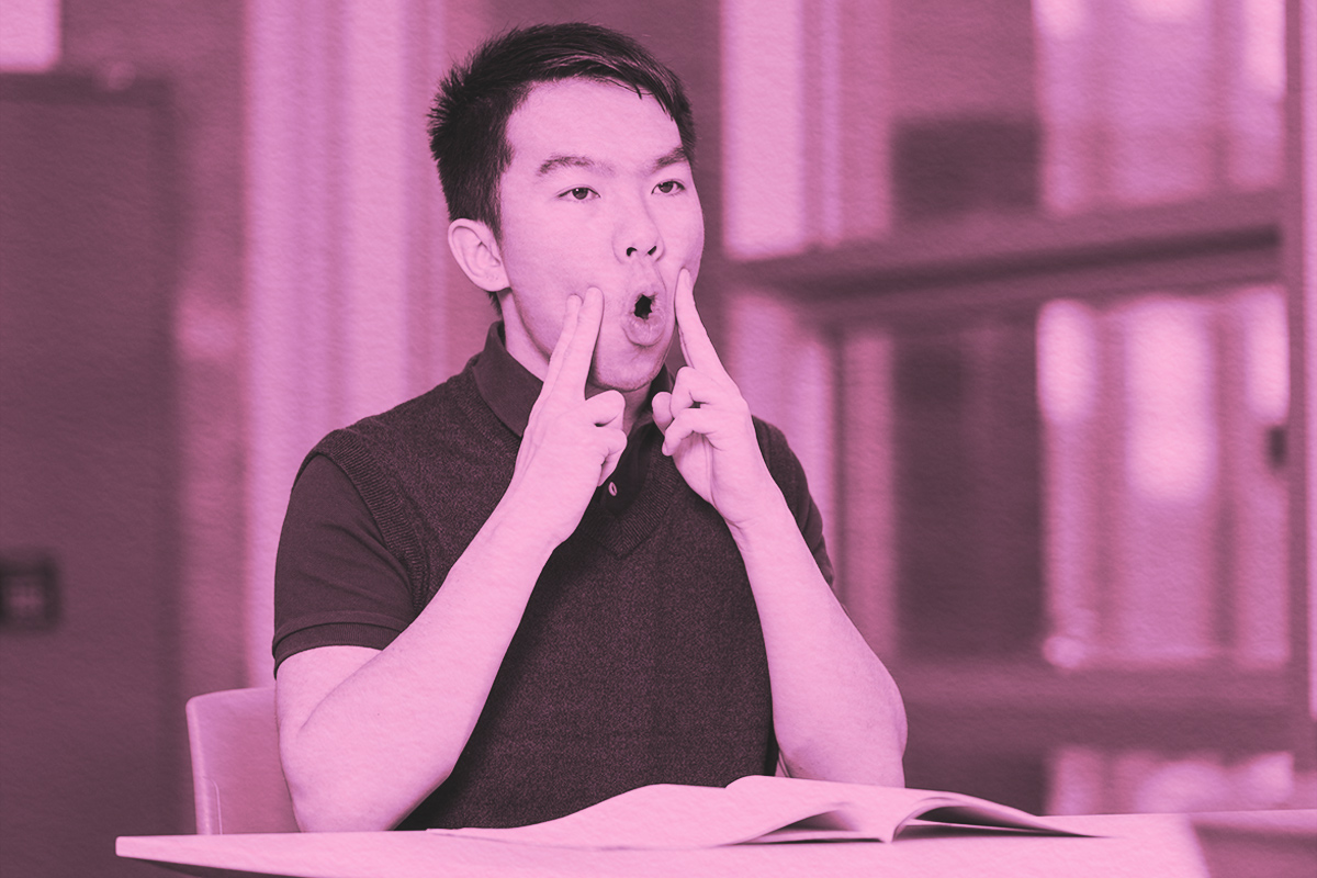 A young teenage boy doing oral motor exercises