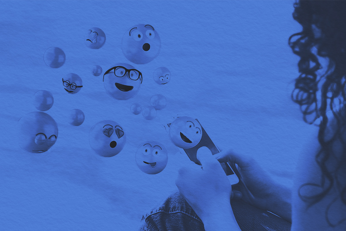 Woman using smartphone sending emojis