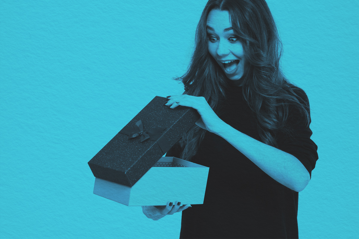 A cheerful woman opening gift box