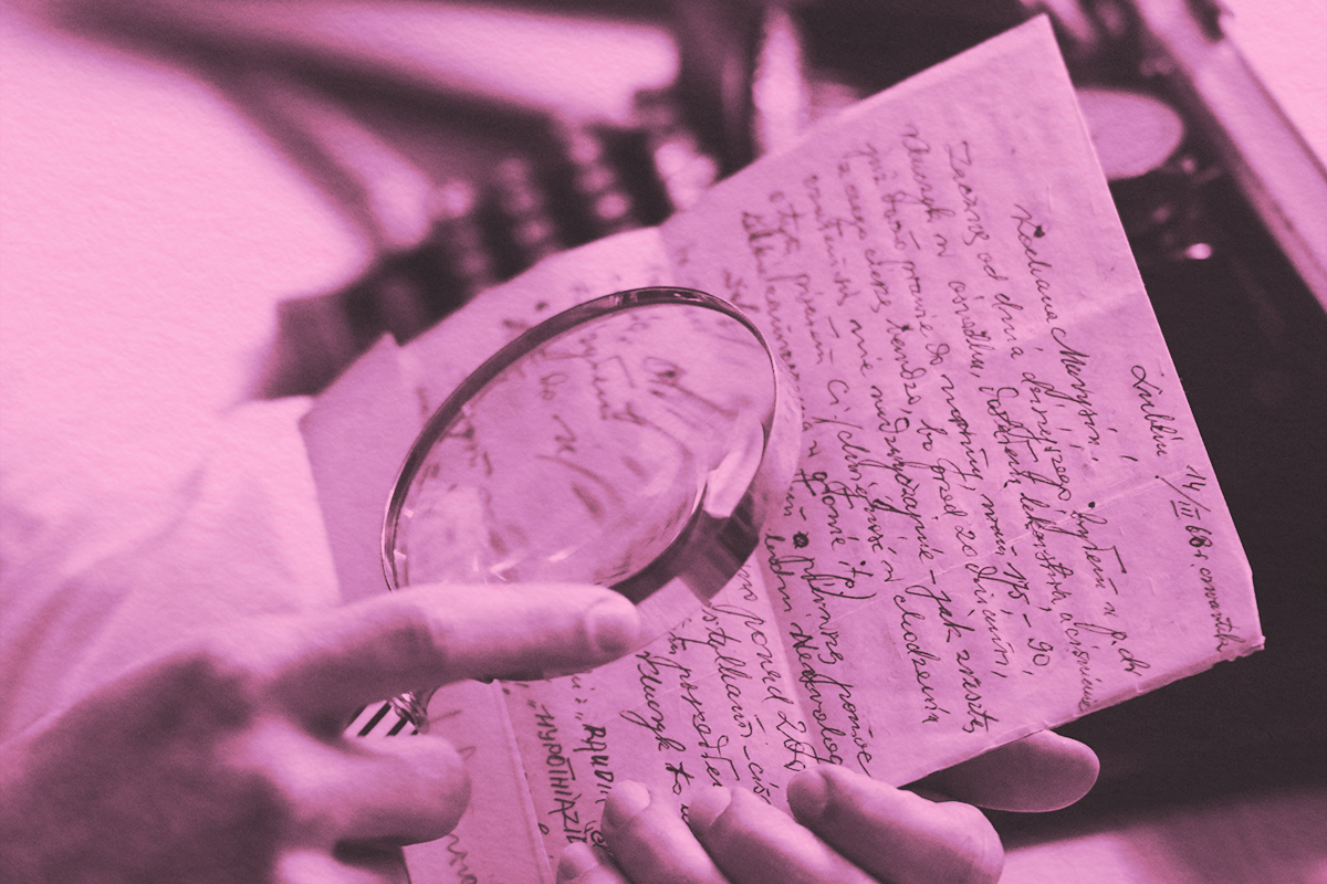 Looking through a magnifying glass to read cursive writing