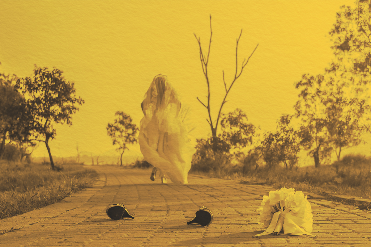 Bride wearing a white wedding dress running away alone in nature