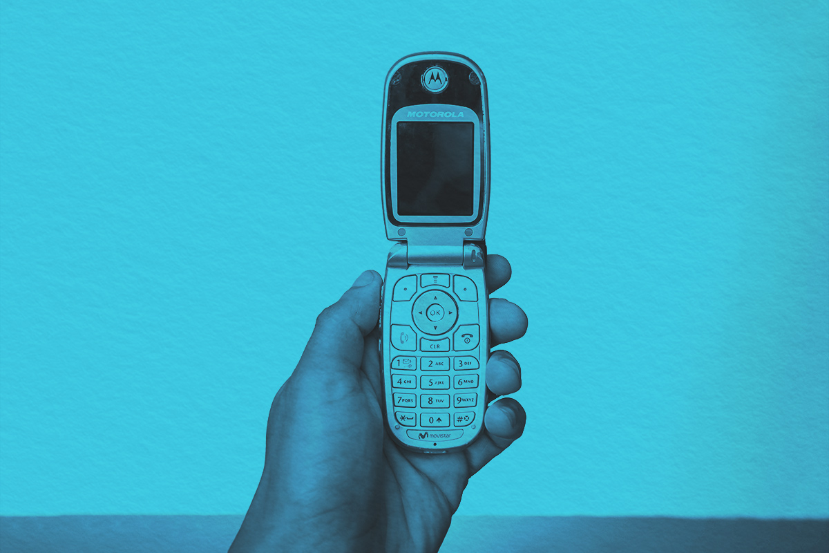 holding old flip phone