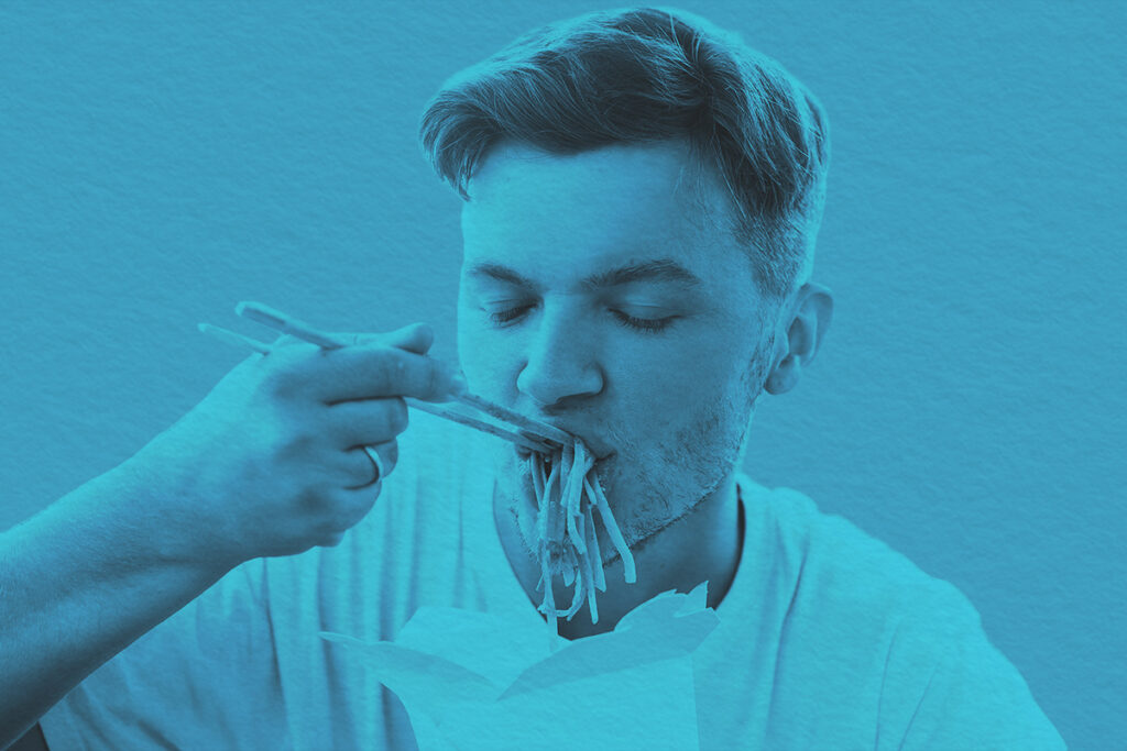 Close-up of a man eating noodles